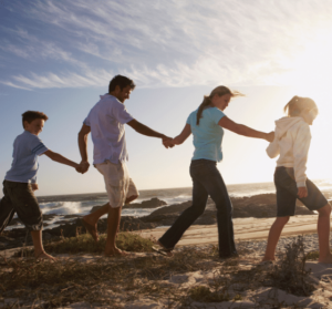 une famille qui se tient la main sur la plage